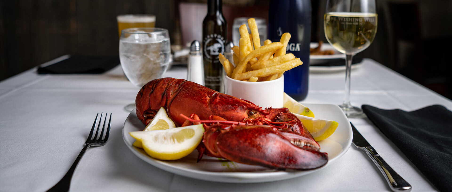 Plate of lobster and fries on a dining room table.